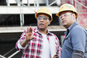 Two construction workers talk at a job site